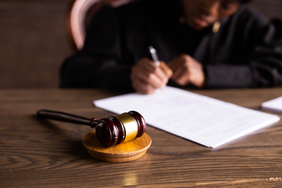 A judge signing on paper with gavel on the table